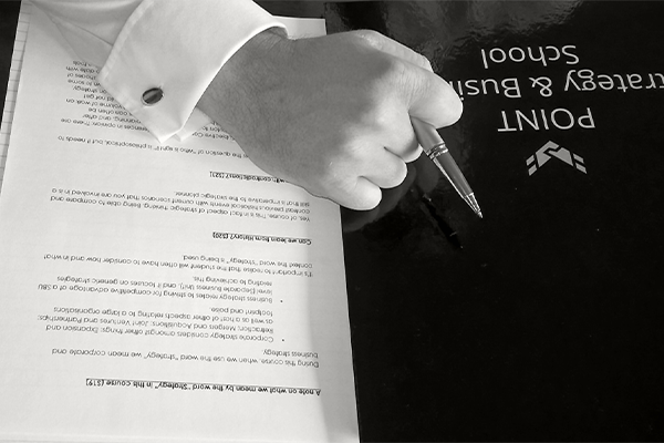 3 business people discussing over a A4 workbook at desk